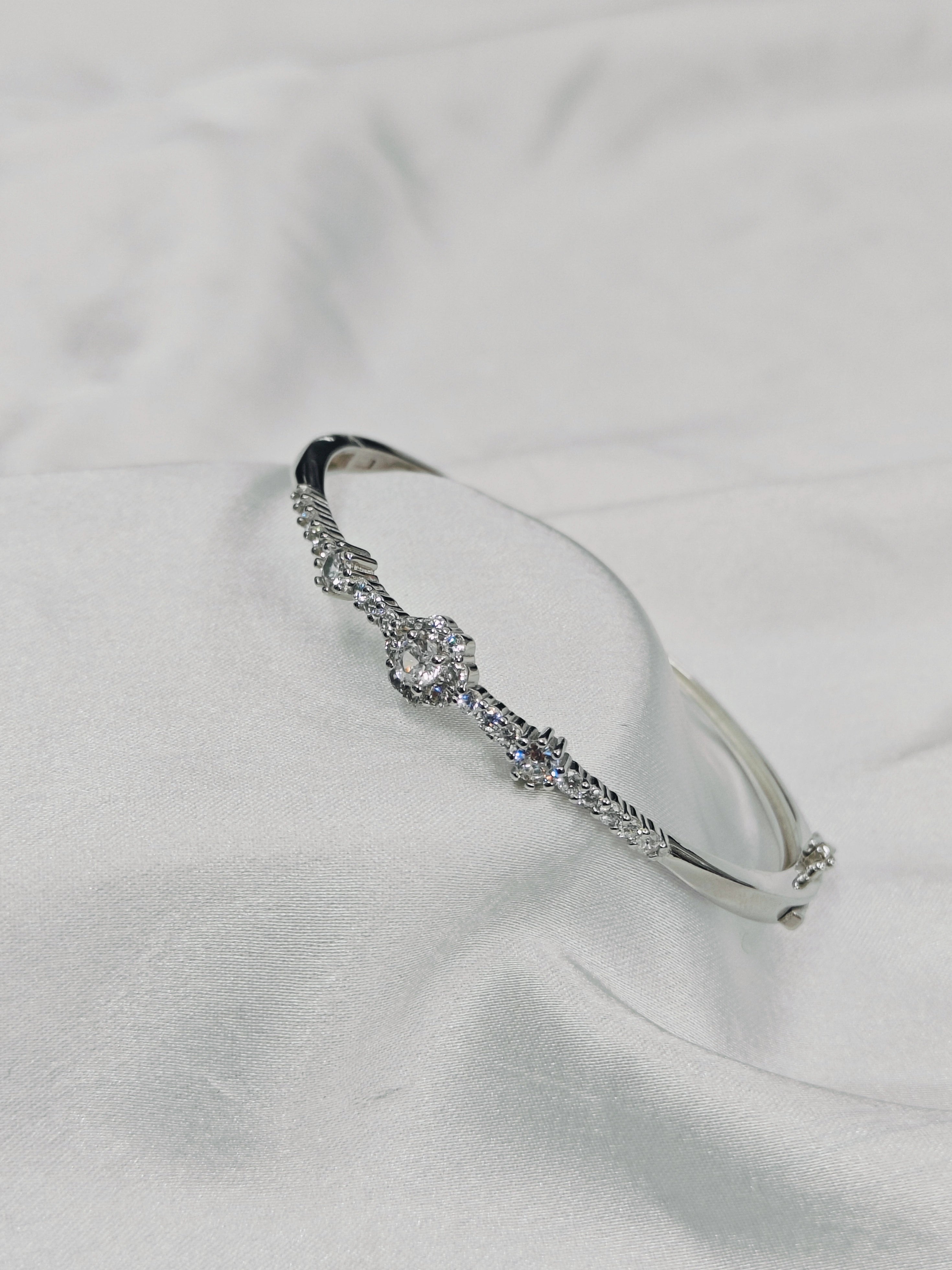 Silver bracelet with clear stones on a light gray background